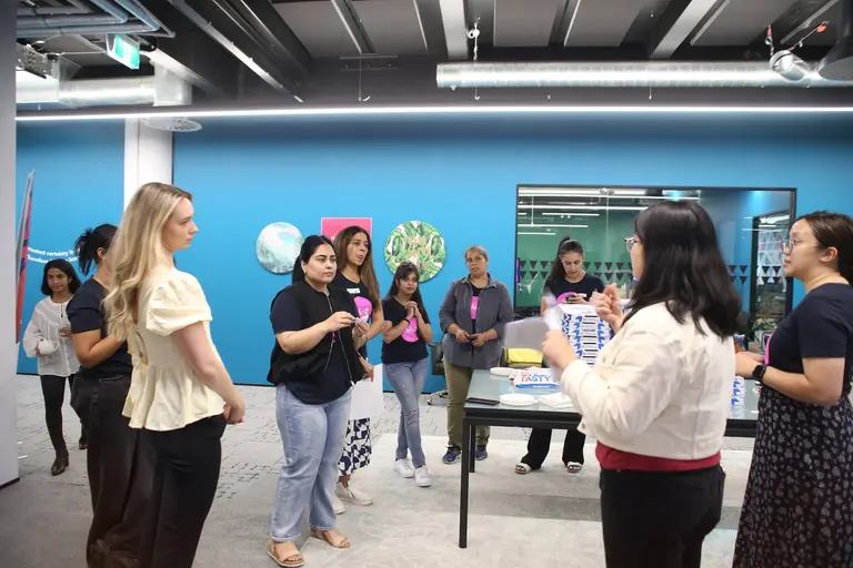 She Sharp members networking together in a bright room at the academyEX International Women's Day event.