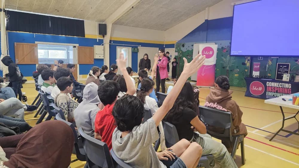 Participants raising their hands to take part in the interactive AI session