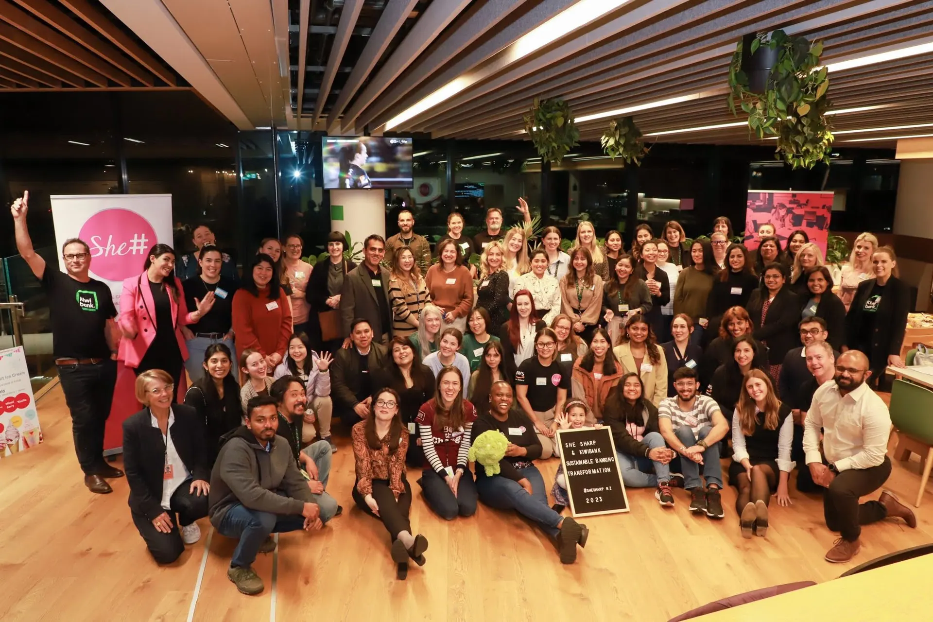 A large, diverse crowd of She Sharp members celebrating together at a community event.