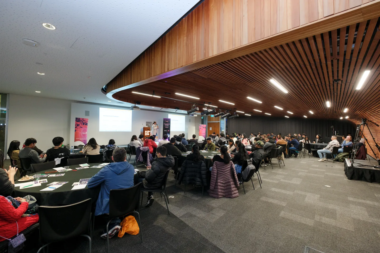 Teams spread across the round tables of AUT's timber-ceilinged hall, laptops open, working through the first day of the hackathon