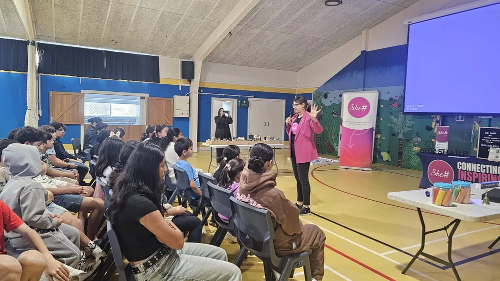 A SheSharp facilitator presenting AI concepts to youth participants at Fruitvale Primary School