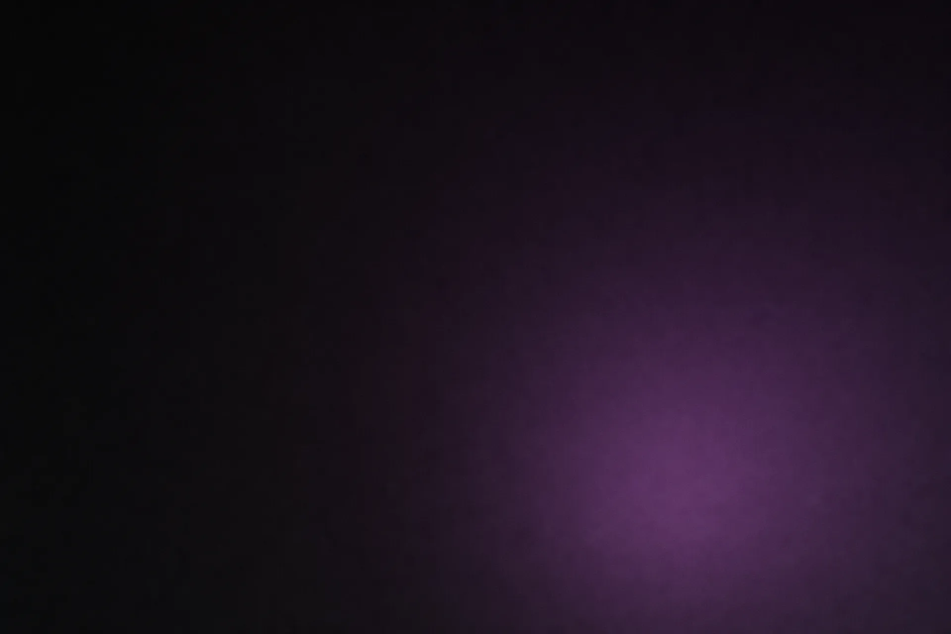 A faint bloom of purple light low in a violet-black field, falling away into darkness.